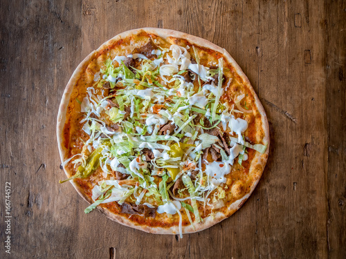 Top view of pizza on wood table.