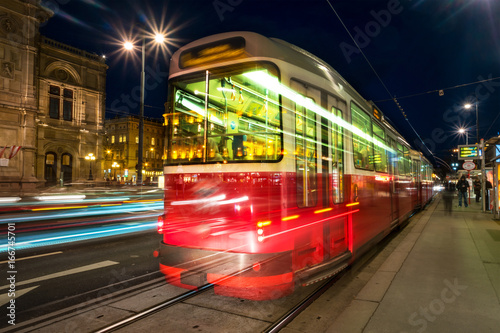 Illuminated Opera house in Vienna, Austria and tram