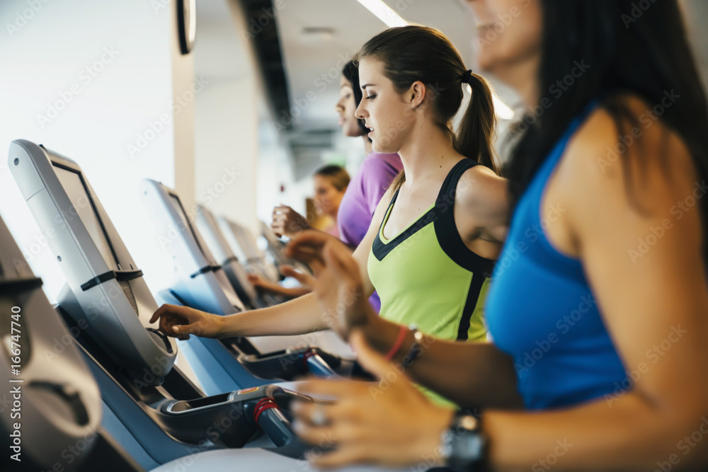 Group of women running on treadmills at a gym Group of women running on treadmills at a gym