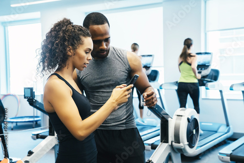 Man and woman looking at a cell phone in the gym 