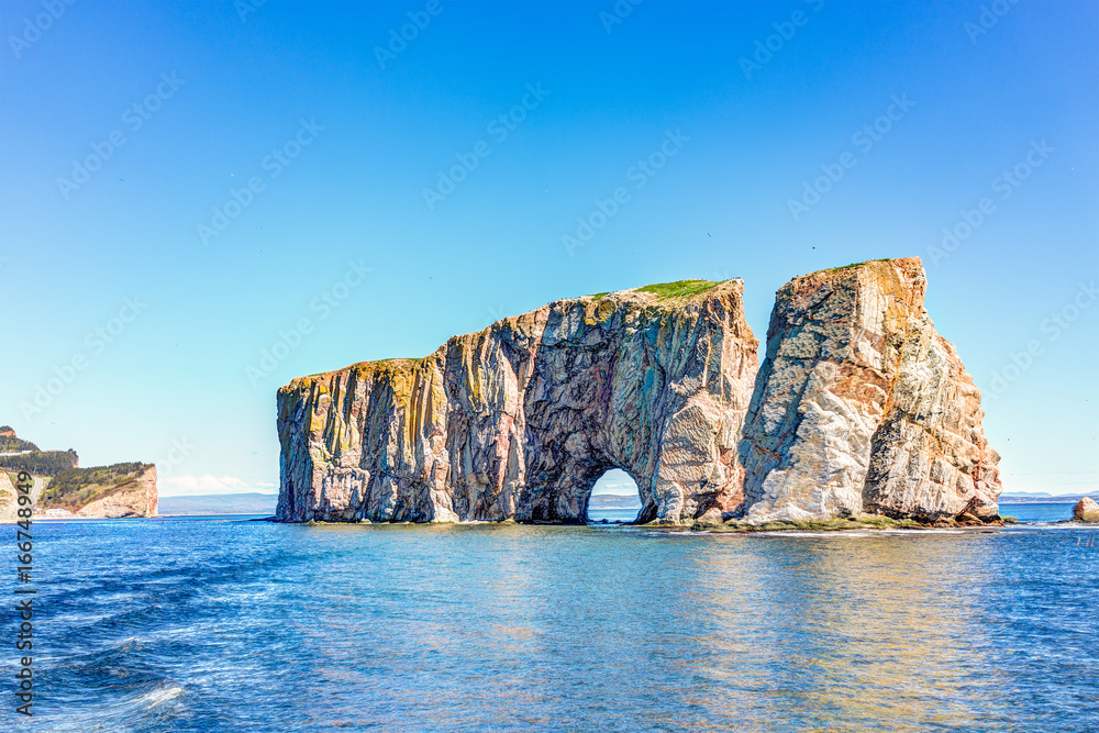 Naklejka premium Rocher Perce rock in Gaspe Peninsula, Quebec, Gaspesie region with birds and cliffs during day