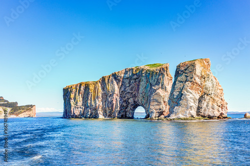 Rocher Perce rock in Gaspe Peninsula, Quebec, Gaspesie region with birds and cliffs during day photo