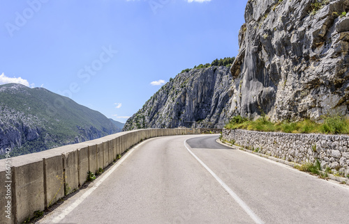 An asphalt road in the rocky mountains near the byss. photo