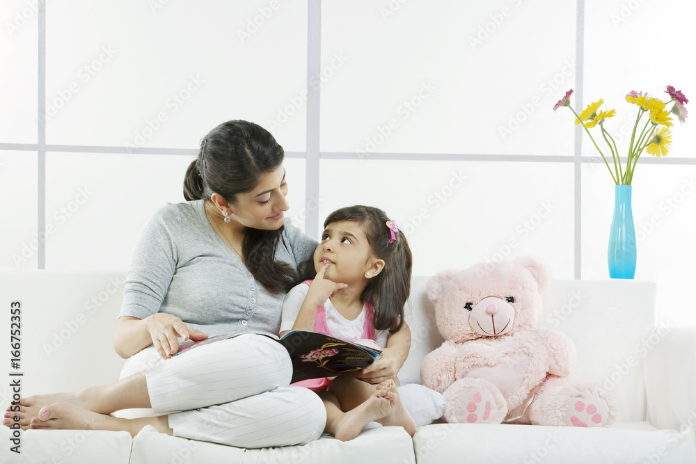Mother and daughter sitting with a magazine Mother and daughter sitting with a magazine