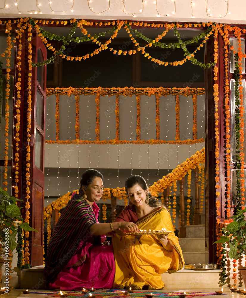 Mother and daughter with a tray of diyas Mother and daughter with a tray of diyas