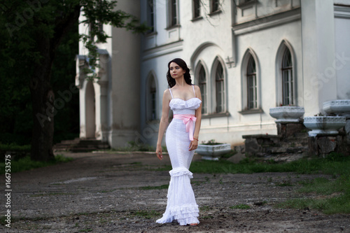 Glamorous young woman in a long white dress