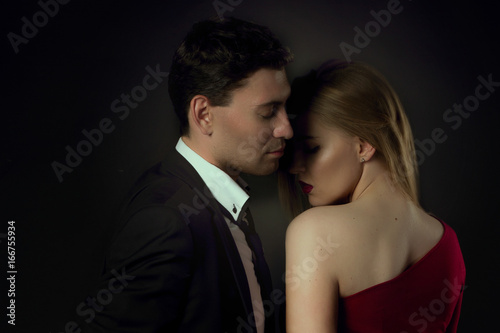 Young couple in evening gown in black background