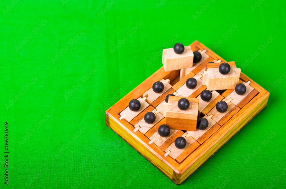 Wooden Brain Teaser or Wooden Puzzles on green background Wooden Brain Teaser or Wooden Puzzles on green background
