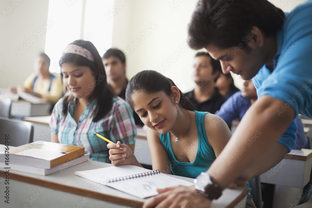 College students looking at notebook College students looking at notebook