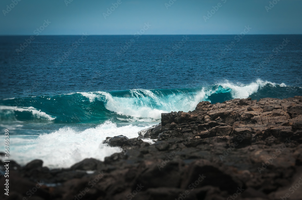 Oceanic waves against the Boca de Abaco volcanic rocks coast with tilt shift effect, Lanzarote, Canary Island