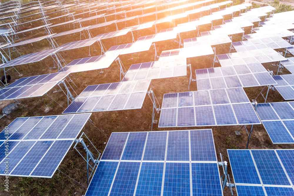 Fototapeta premium Beautiful sunset over Solar Farm with sunset on the backgroundใ Power plant using renewable solar energy