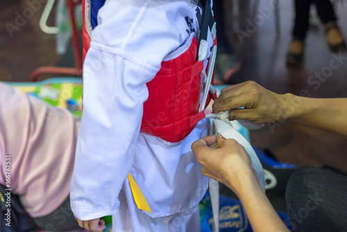 Young Taekwondo athletes dress up for fighting in contest. © GypsyGraphy