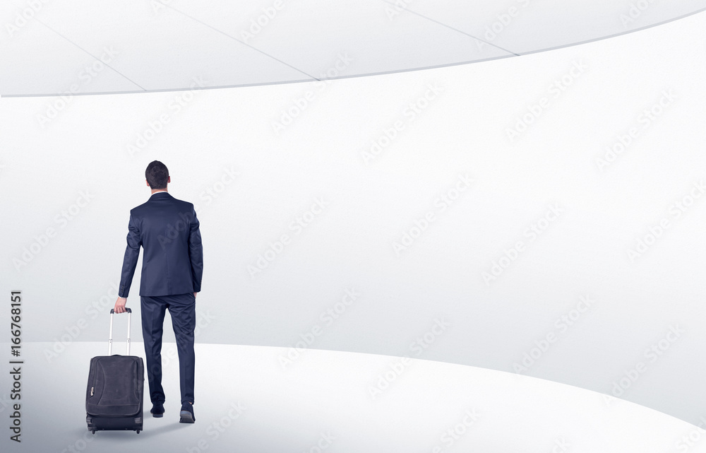Businessman with suitcase walking in waiting room Businessman with suitcase walking in waiting room
