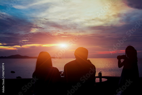 family at table on beach on sunset