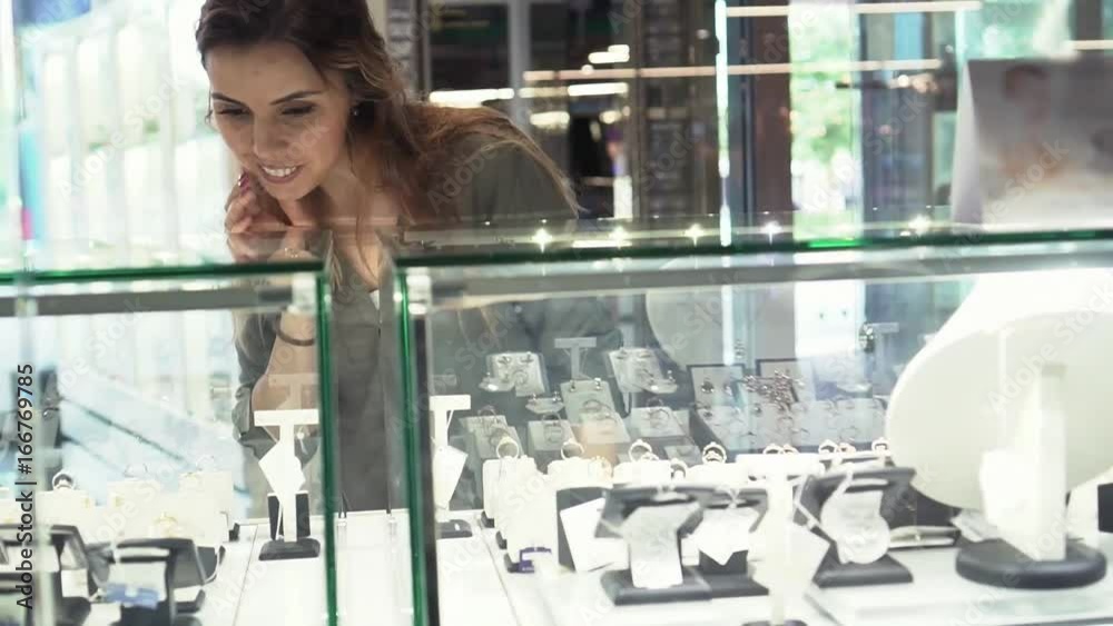 Young woman looks at the jewelry store window