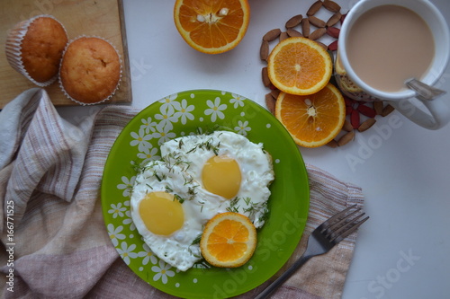  Breakfast. Fried eggs with orange, cocoa and cupcakes.