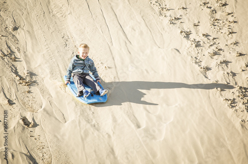 Thrill seeking boy Playing in the Sand Dunes Outdoor Lifestyle
