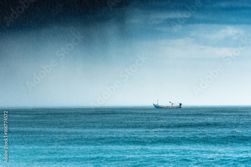 raining in the sea with fishing boat during the rainy season.