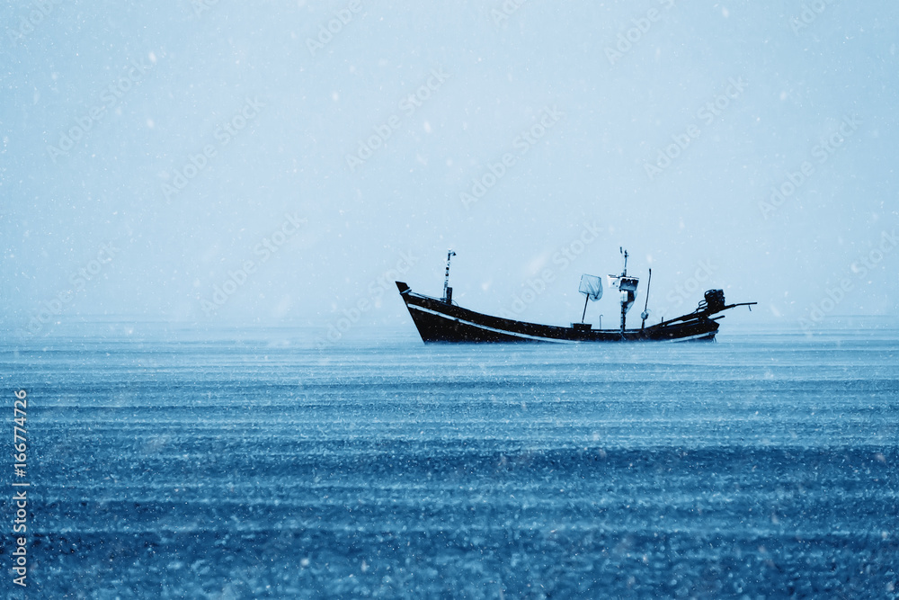 Fishing boat on the sea with snowfall in winter color tone. Fishing boat on the sea with snowfall in winter color tone.