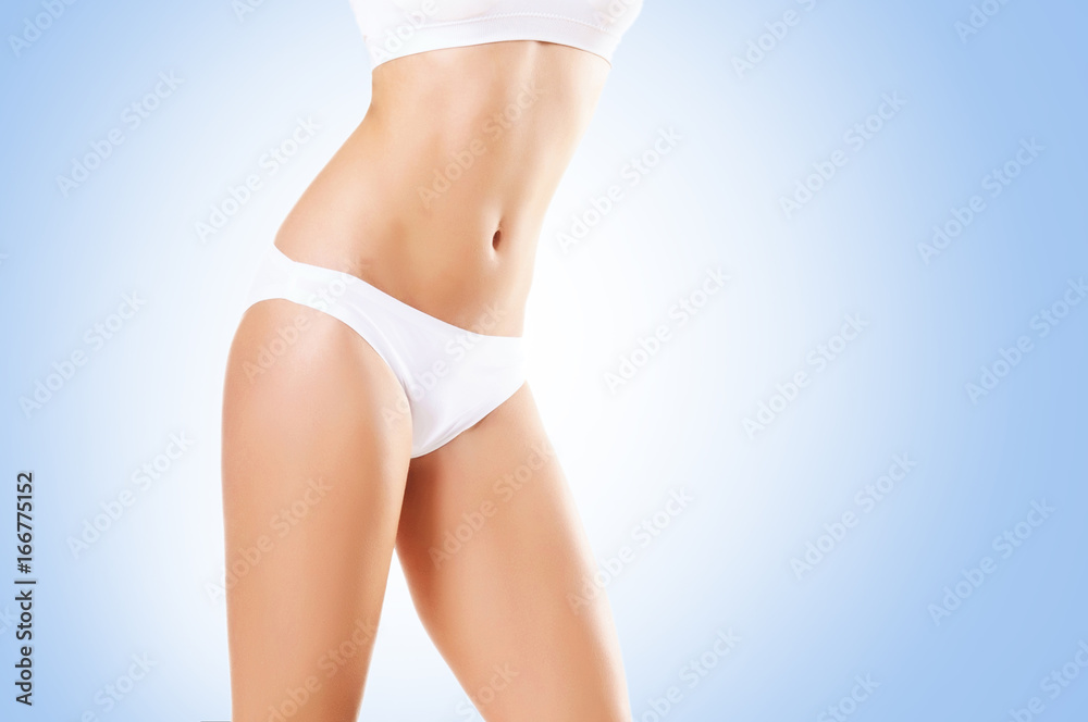Fit and sporty girl in white underwear. Beautiful and healthy woman posing over blue background. Sport, fitness, diet, weight loss and healthcare concept.