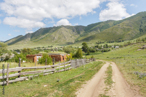 Country road in the village on a background of mountains
