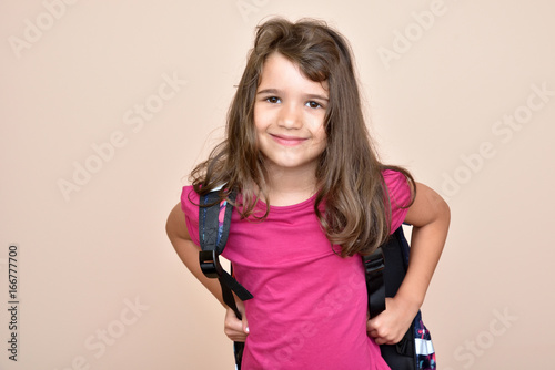 Smiling young girl with school bag