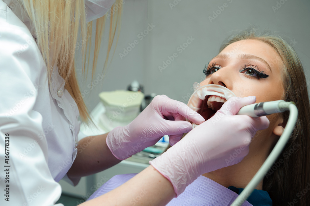 Naklejka premium female dentist treating patient