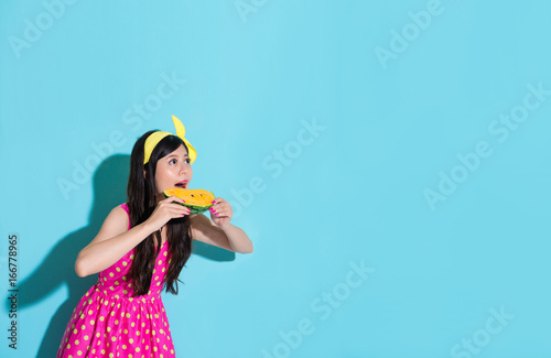 girl looking at empty area eating watermelon