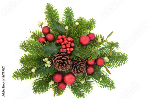 Decorative christmas greenery with holly ivy, mistletoe, fir, red bauble decorations and pine cones on white background.