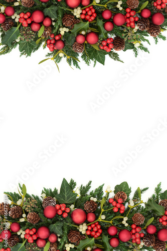 Christmas decorative border with red bauble decorations, holly, ivy, mistletoe, fir and pine cones on white background. 