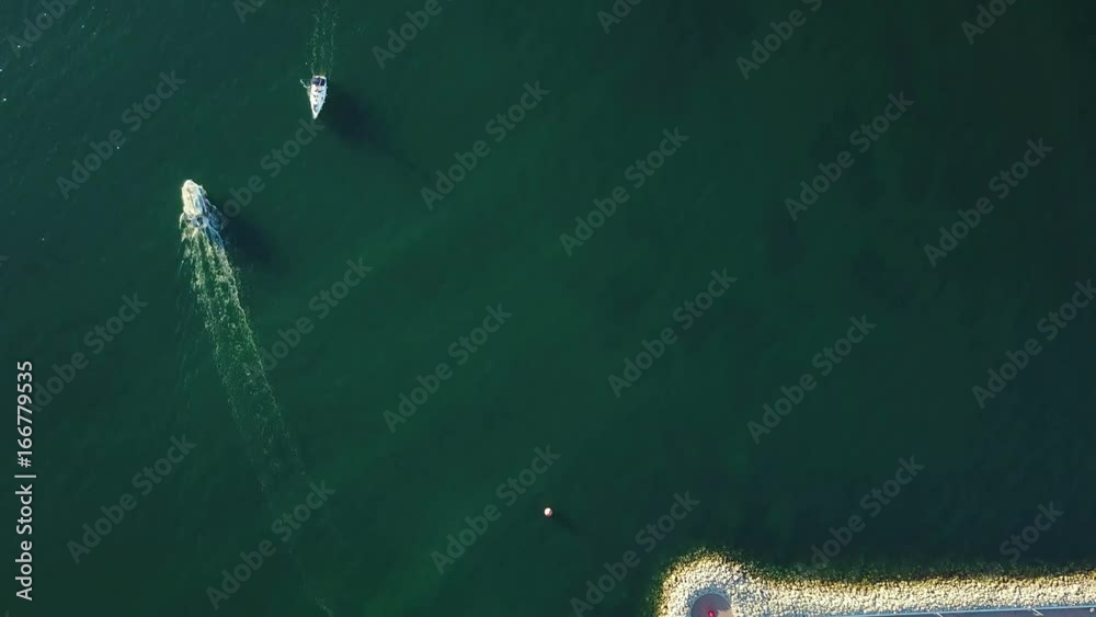 4K. Flight over marina with floating yachts and lighthouse, aerial bird's eye view at sunset. 4K. Flight over marina with floating yachts and lighthouse, aerial bird's eye view at sunset.