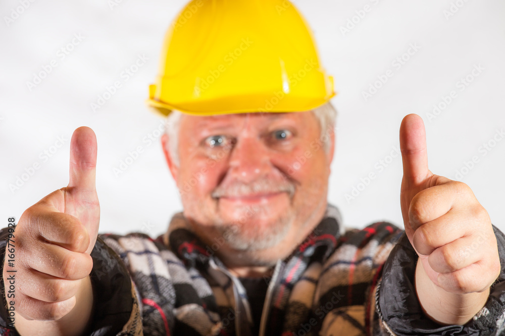 A craftsman smiles and pointing with the thumb up A craftsman smiles and pointing with the thumb up