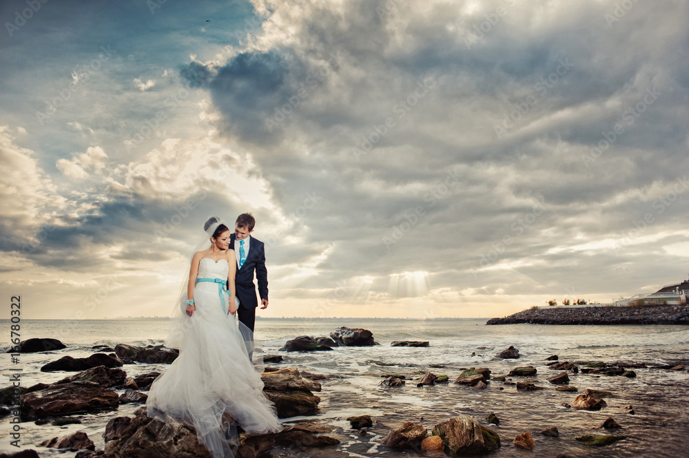 Wedding couple on a walk by the sea Wedding couple on a walk by the sea