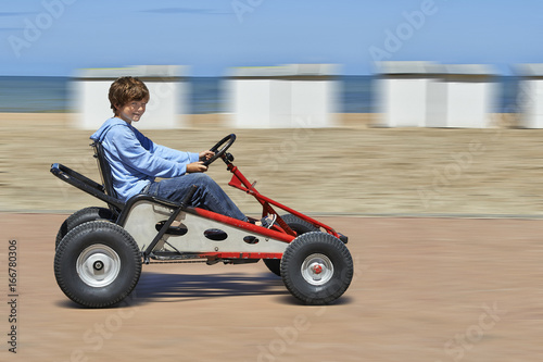 Young boy driving a Quadricycle
