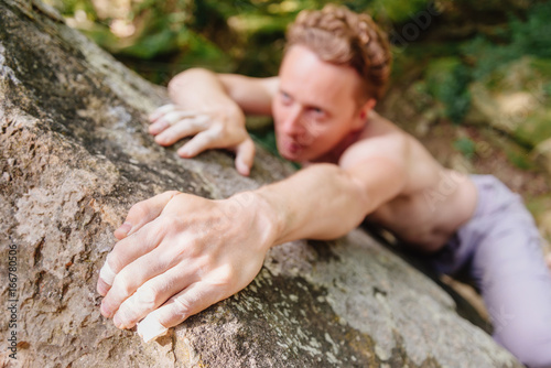 Man climbing on boulder.