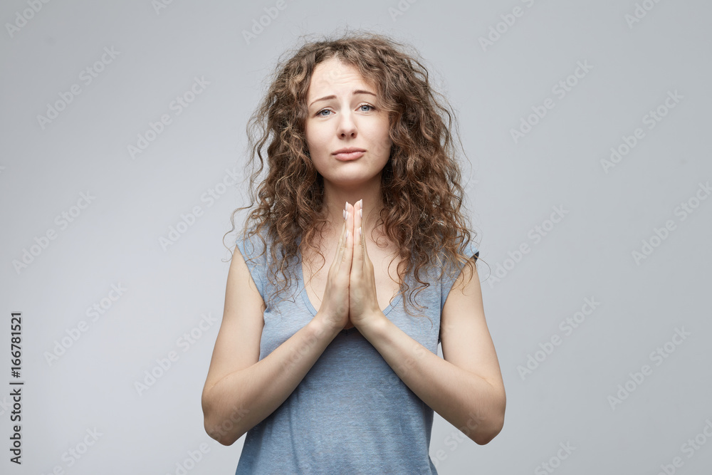 Indoor isolated shot of beautiful female posing in studio keeping hands ...