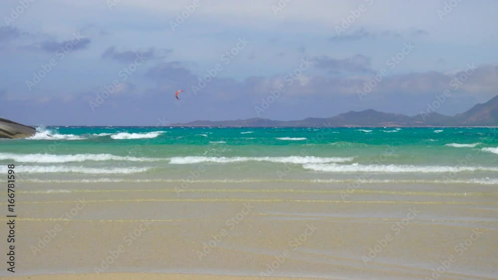 Kitesurfing and Windsurfing in a Windy Bay in Sardinia Italy Kitesurfing and Windsurfing in a Windy Bay in Sardinia Italy