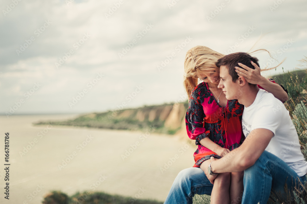 Couple in love on a cliff above the sea