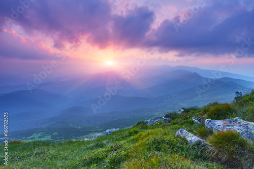 summer landscape in the mountains with the sun at dawn photo