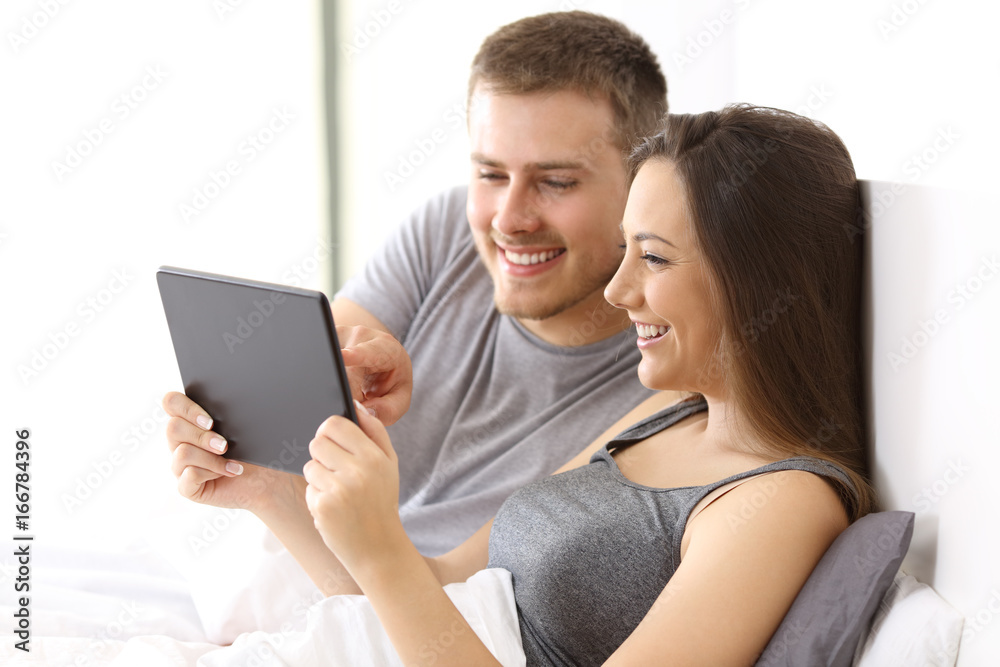 Couple watching media content on the bed Couple watching media content on the bed