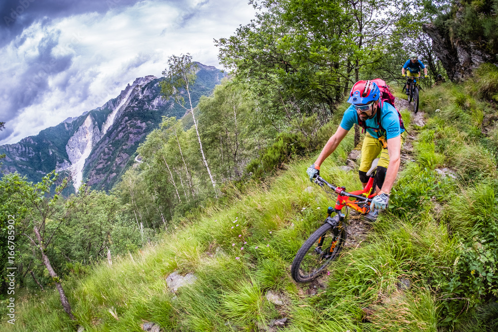 Colourful Mountain biker in big mountains in Tuscany