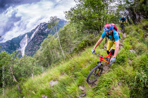 Colourful Mountain biker in big mountains in Tuscany