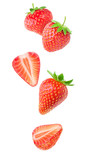Isolated strawberries. Falling strawberry fruits whole and cut in half isolated on white background with clipping path