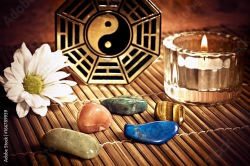 Ying yang, i-ching with healing stones, candle and a daisy flower like a concept of chinese oriental astrology  photo