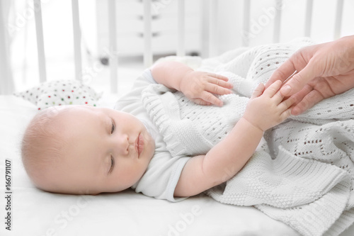 Cute baby lying in cradle a...