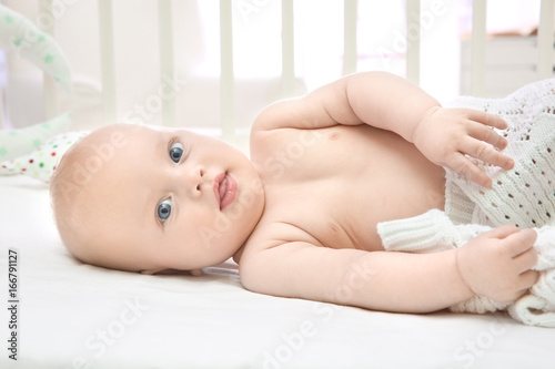 Cute baby lying in cradle. ...