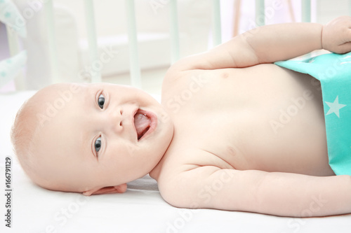 Emotional baby lying in cra...