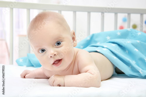 Emotional baby lying in cra...