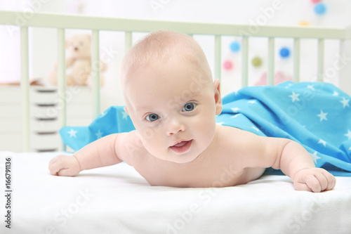 Emotional baby lying in cra...