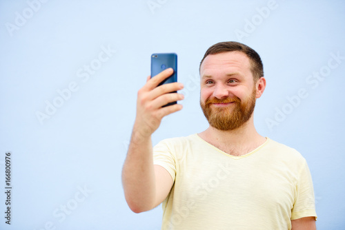 A man makes faces in a funny and humorous phone makes serious faces, an advertising company